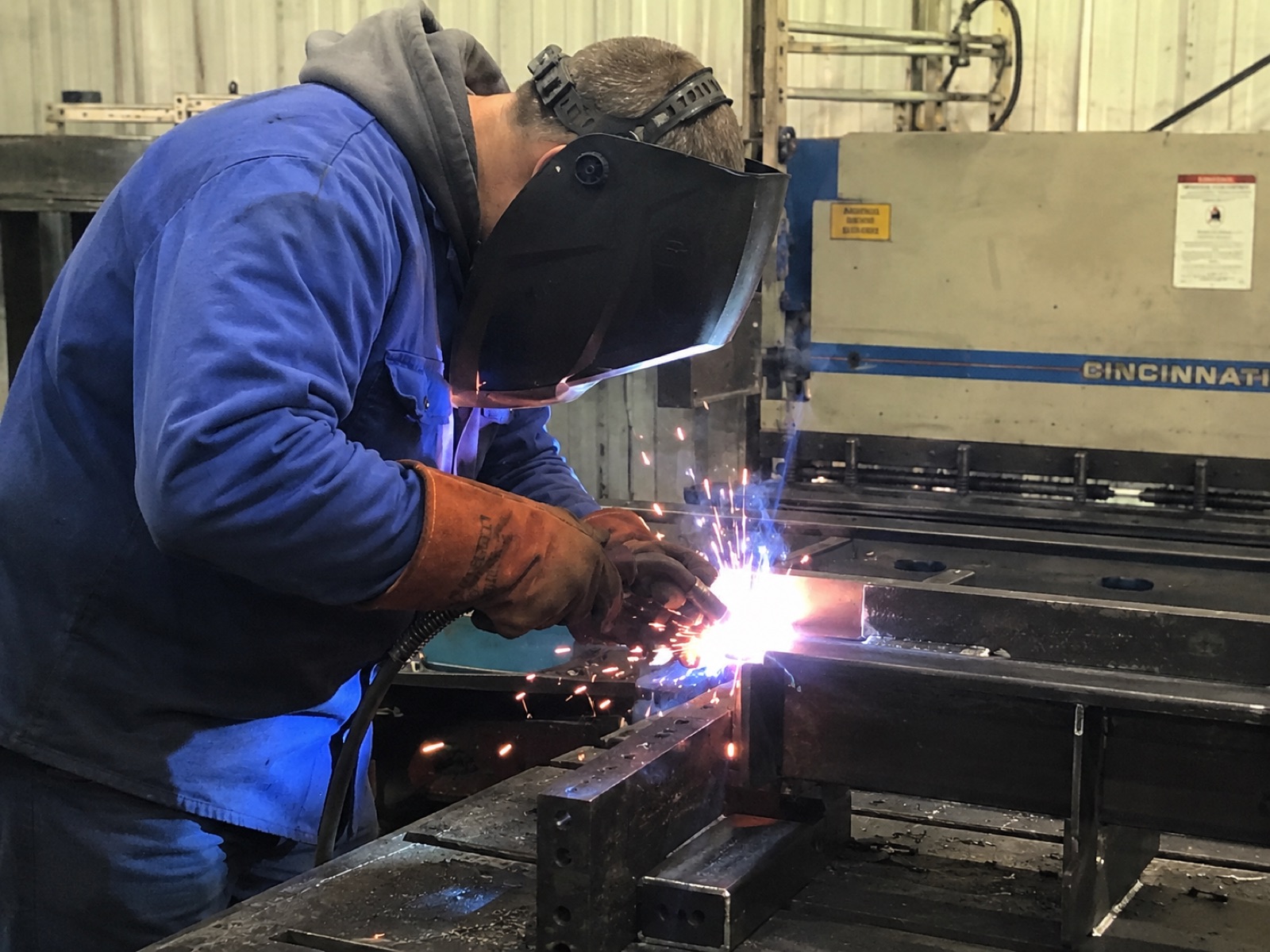 Welder fabricating a custom metal railing in the Alameda Custom Railing shop